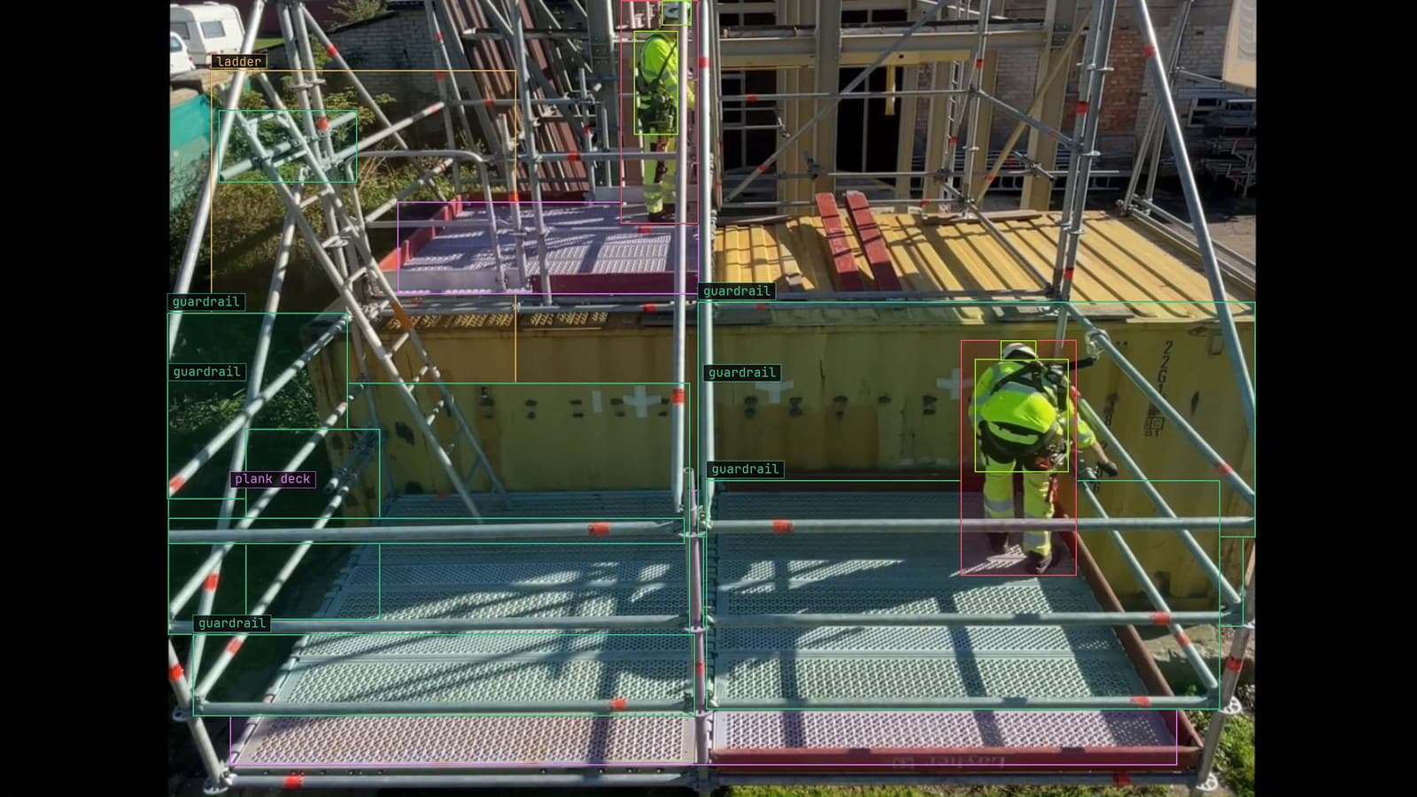 Scaffold with two workers, guardrails, ladder and plank decks boxed, from a customer site camera