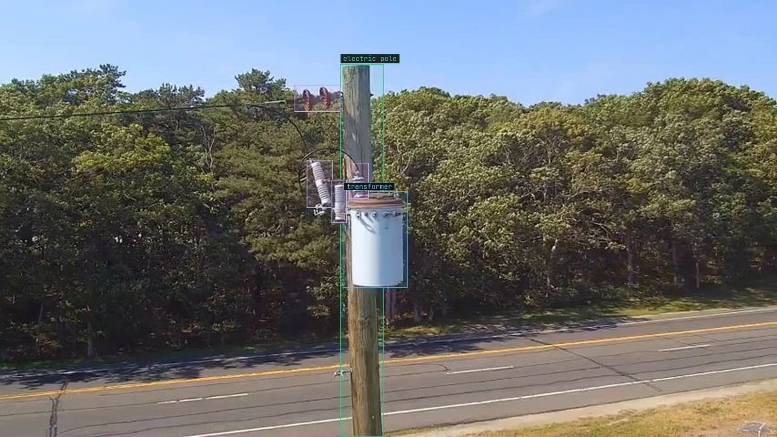 A pole-mounted transformer with its insulators boxed from the ground, from a customer inspection run