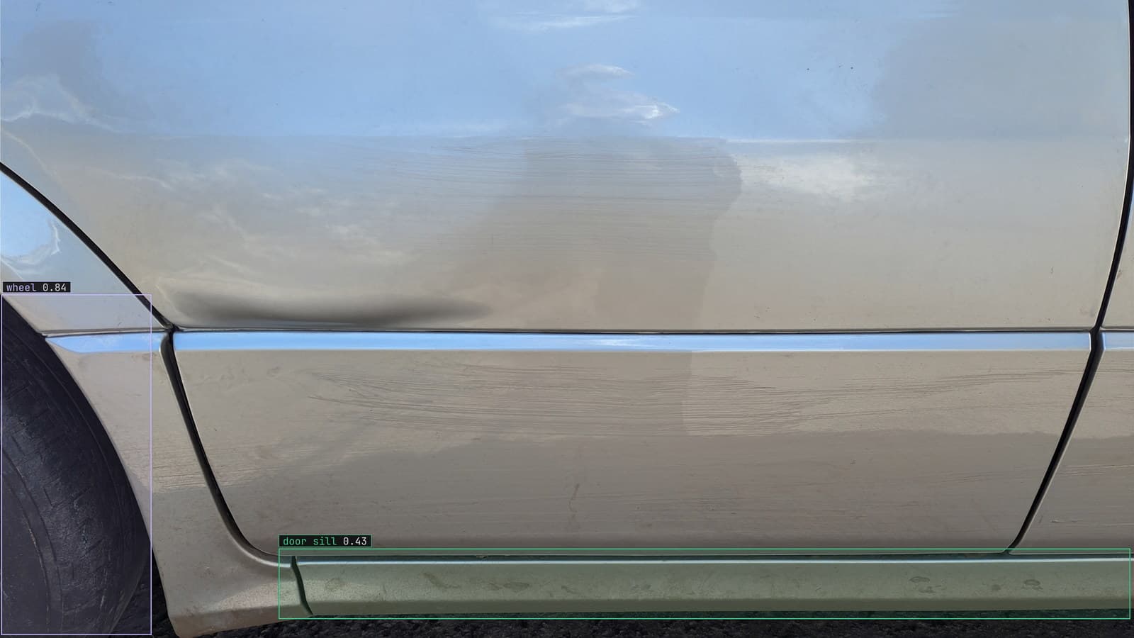 Vehicle door sill and wheel boxed in a claims photo, generated scene with detections from our model