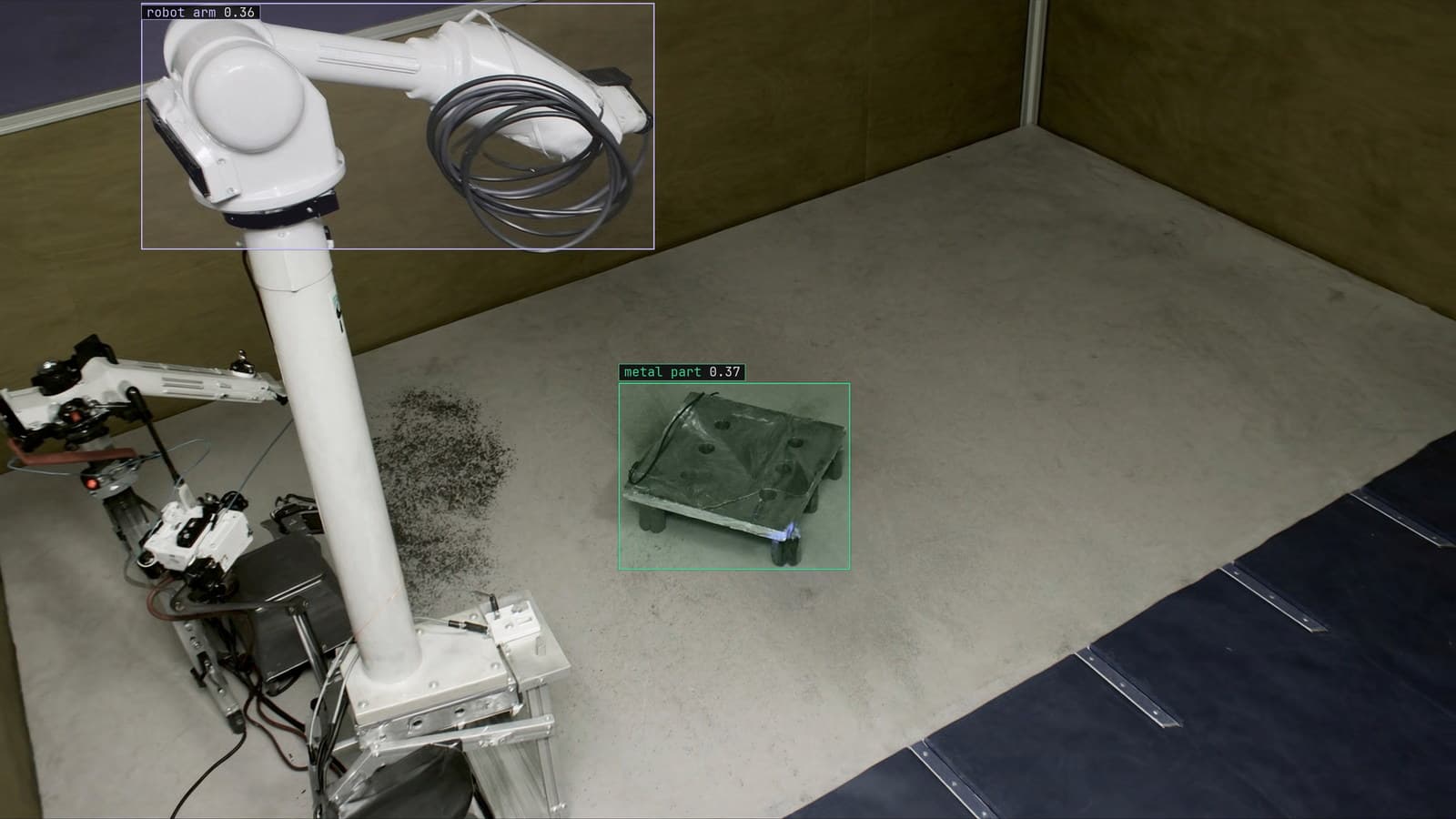 Robotic welding cell with a part on the fixture, metal part and robot arm boxed, generated scene with detections from our model