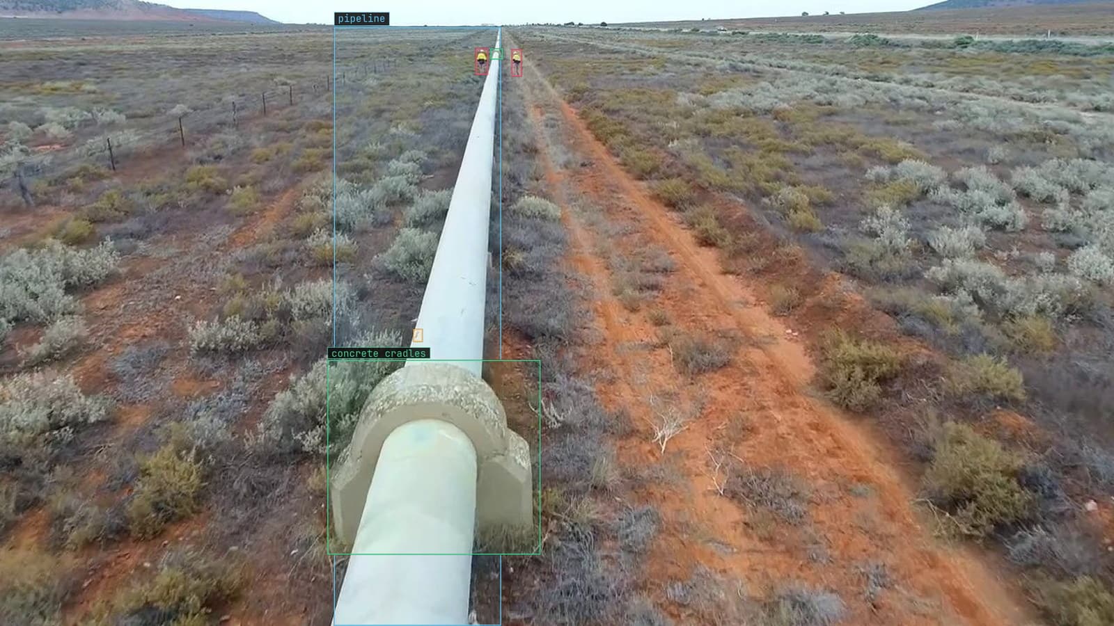Pipeline across scrub, concrete cradles boxed and a rust mark flagged, from a customer drone survey