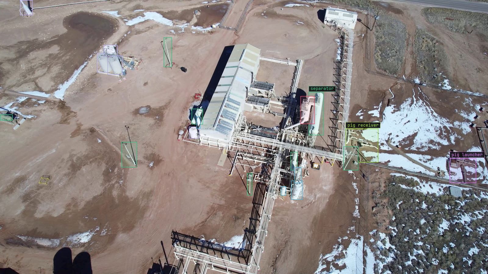 Well pad with heaters, separators and tanks boxed, from a customer aerial survey, the kind of label set that has to survive a move